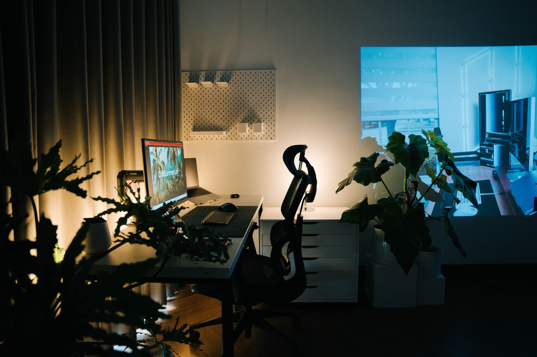 Escritorio de oficina en casa con iluminación cálida y plantas, ideal para productividad.