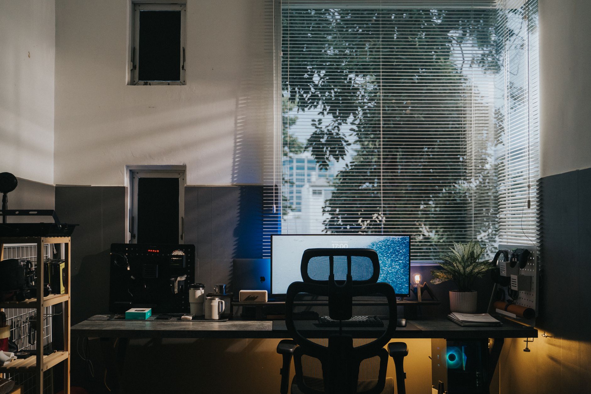 Acogedor espacio de oficina en casa con escritorio, monitor, silla e iluminación natural.