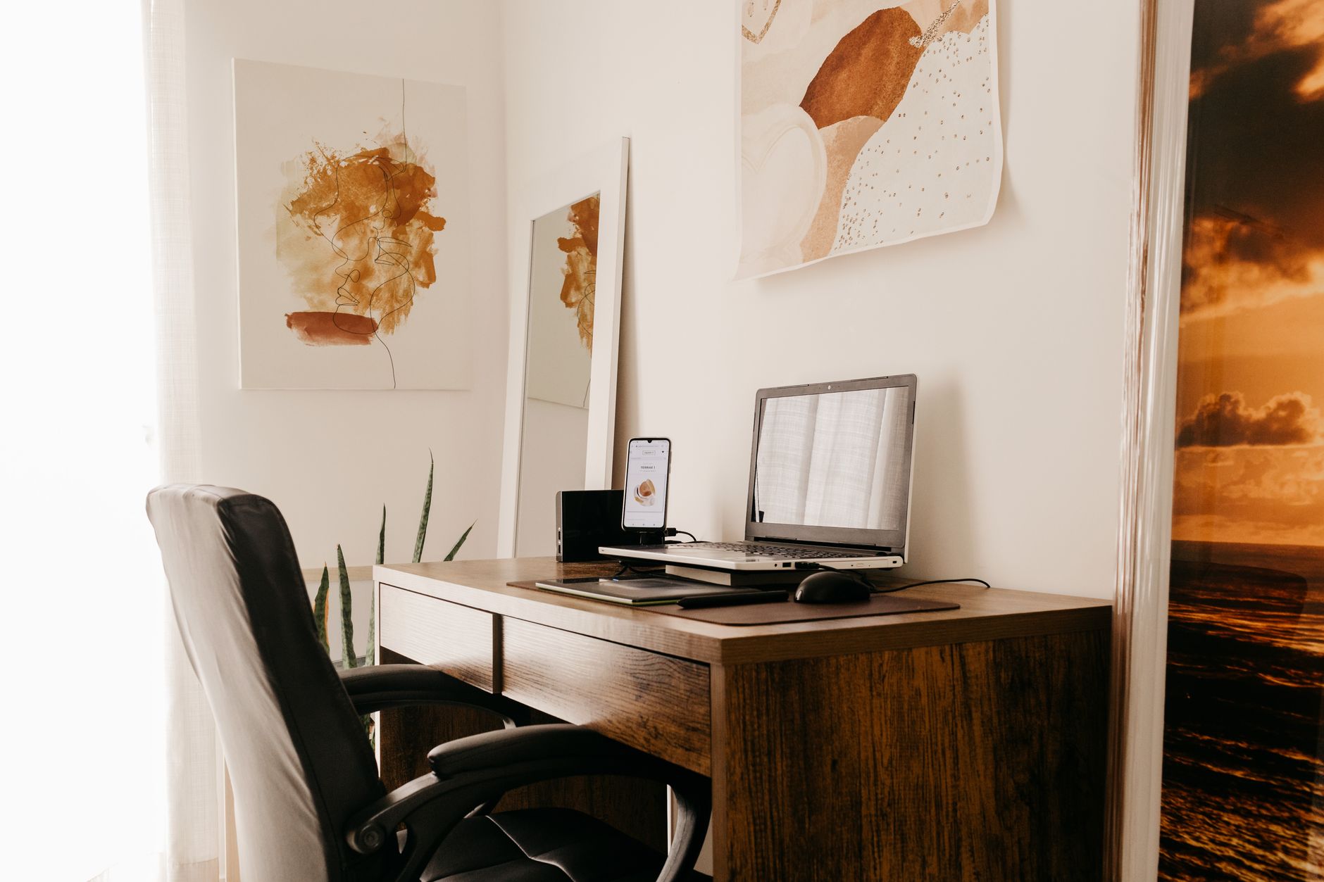 Espacio de trabajo cómodo con portátil y varios dispositivos en un apartamento luminoso durante el día.
